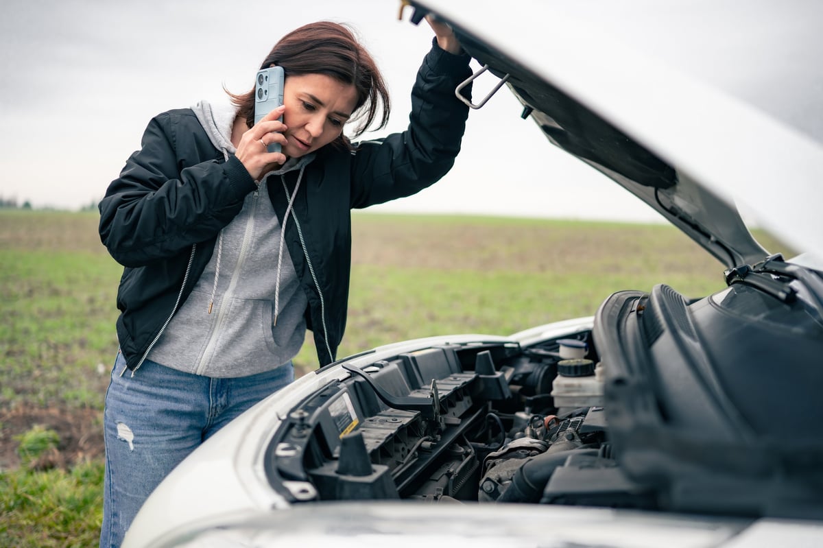 Driver with a broken-down car calling for breakdown recovery